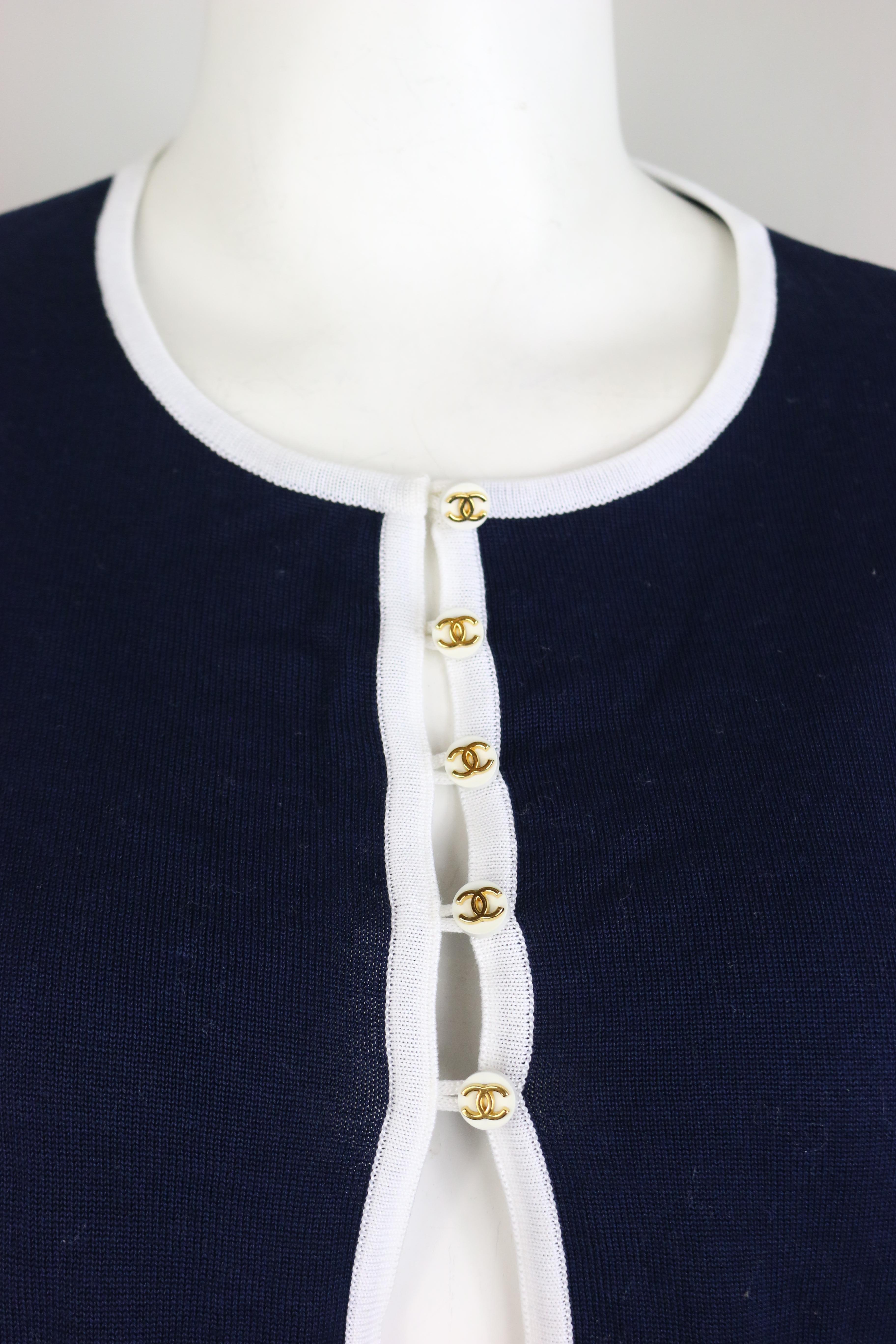 - Vintage Chanel navy with white piping trim cotton knitted cropped short sleeves cardigan top from 1996 spring collection. 

- Featuring gold-toned 