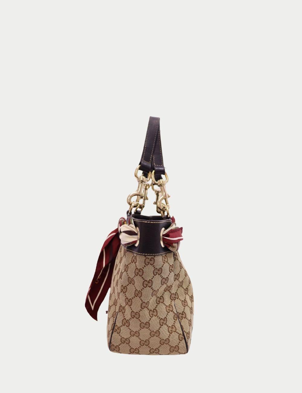 Gucci Vintage Monogram Canvas Tote with Silk Scarf Accent (Fourre-tout en toile avec monogramme et foulard en soie)

La sophistication intemporelle rencontre le charme vintage dans ce fourre-tout en toile avec monogramme Gucci, une pièce de