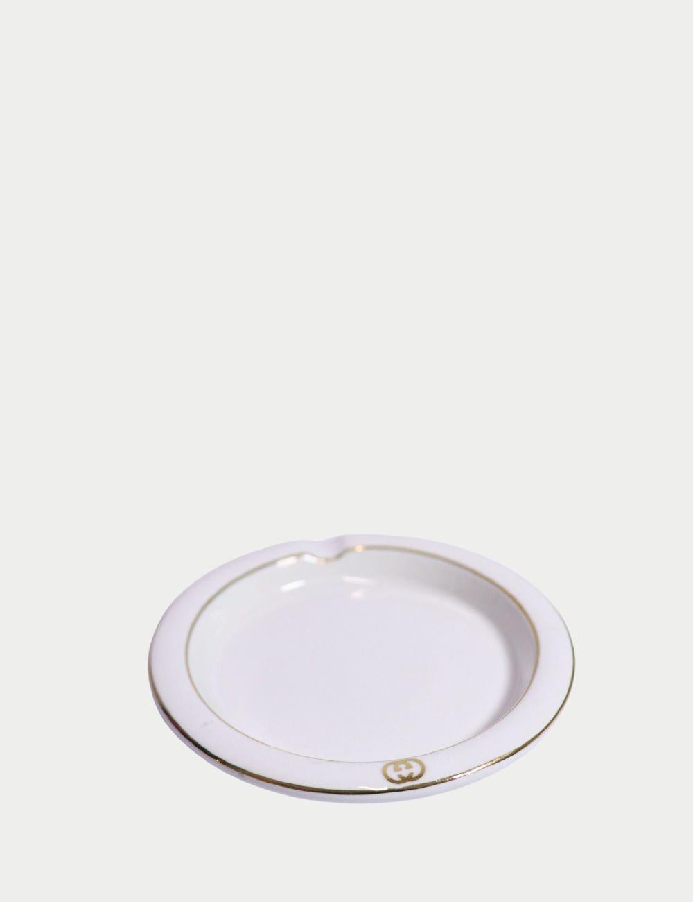 Vintage Gucci Porcelain Ashtray – White & Gold Made in Italy

Add a touch of vintage Italian luxury to your space with this authentic Gucci porcelain ashtray. Crafted in Italy, this elegant white ashtray features a sleek gold trim and subtle Gucci