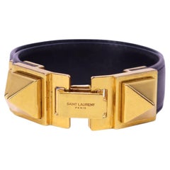 Brazalete llamativo de Saint Laurent, de cuero negro con detalles dorados