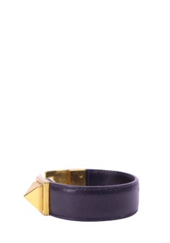Brazalete llamativo de Saint Laurent, de cuero negro con detalles dorados