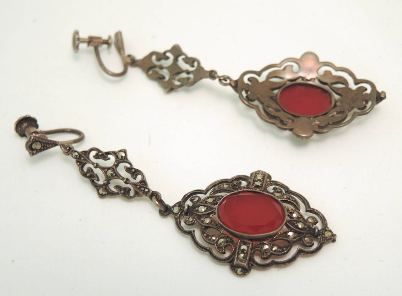 These vintage deco German earrings feature carnelian stones with marcasite accents in a sterling silver setting.  These German screw-clip earrings measure 2 5/8” x 7/8” and are in excellent condition.