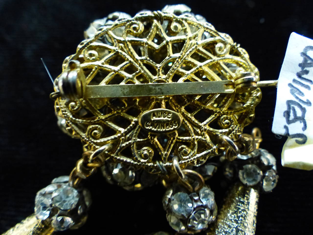 This vintage signed Alice Caviness pin features etched gold-tone beads with clear rhinestone accents in a gold-tone setting.  This pin measures 2 7/8” x 1 7/8”, is signed ‘Alice Caviness’ and is in excellent condition.