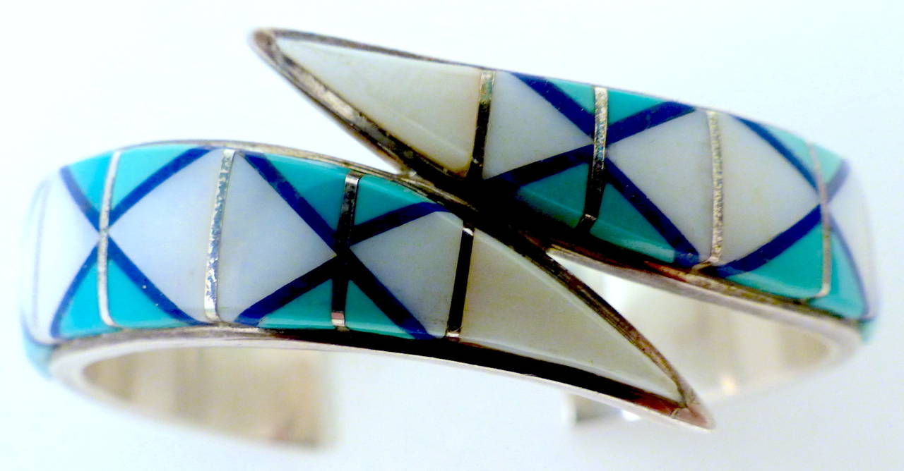 This vintage cuff is by Teme, a wholly-owned subsidiary of the Navajo Nation.  This bracelet features turquoise and mother-of-pearl in a sterling silver setting.  This cuff measures 6 3/8” around the inside and the front is 7/8” wide.  This vintage