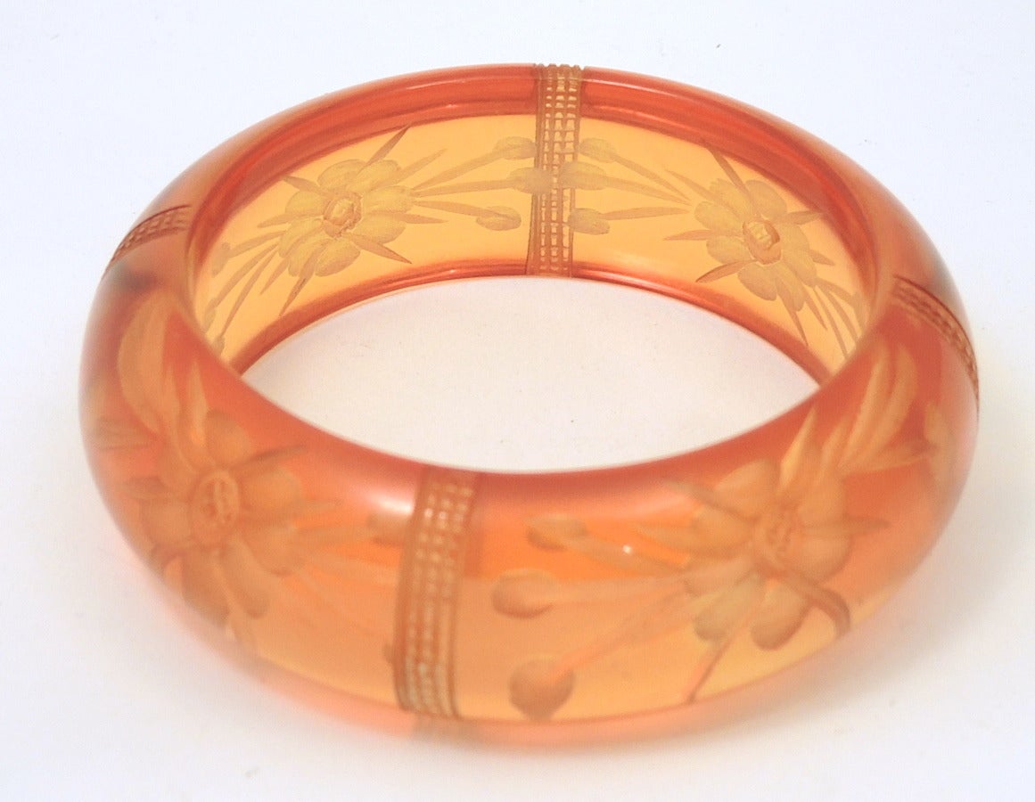 This vintage deco bangle bracelet features a carved apple juice bakelite setting.  This bangle bracelet measures 7 ¾” x 1” and is in excellent condition.
