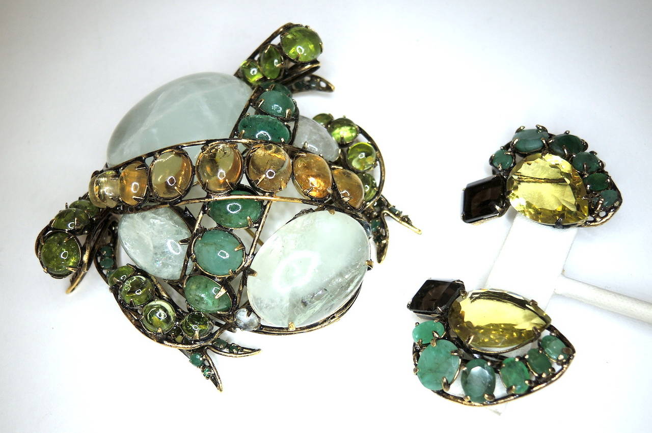 This vintage 1980’s  Iradj Moini set features a Frog pin with real emerald, citrine and aquamarines in a gold-tone setting.  The pin measures 3 ½” x 2 7/8” with a turn closure; the clip earrings are 1 ½” x 1 1/8”.  This vintage set is signed Iradj