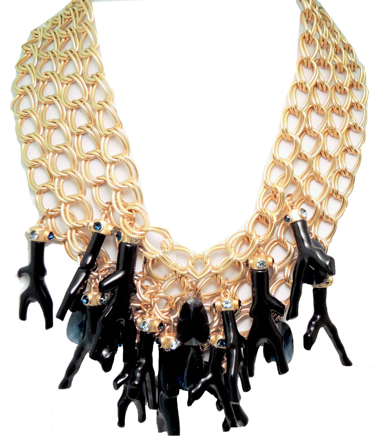 This vintage signed Oscar de la Renta necklace features multiple faux coral shaped black branches.  It also has bezel cut teardrop sapphire blue glass stones with sapphire and blue color rhinestone accents.  They all cascade down from a wide golden