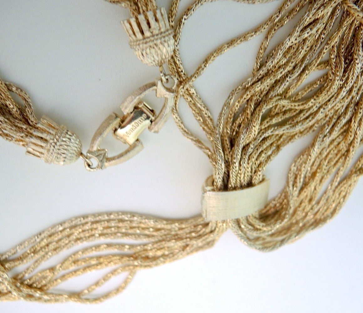 If am fascinated by tassels.  I see them used in every aspect of jewelry and they always sell.  I love them! This signed Vendome necklace features a multi-strand tassels in a twist gold-tone setting.  This necklace measures 20” with a fold-over