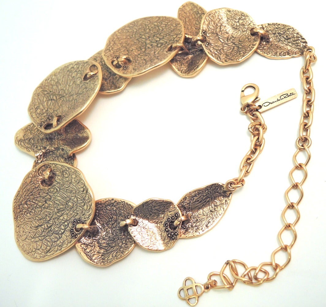 This Oscar de la Renta necklace features  gold-tone metal discs.  In excellent condition, this necklace measures 22” x 1 7/8” with a spring closure and is signed “Oscar de la Renta”.