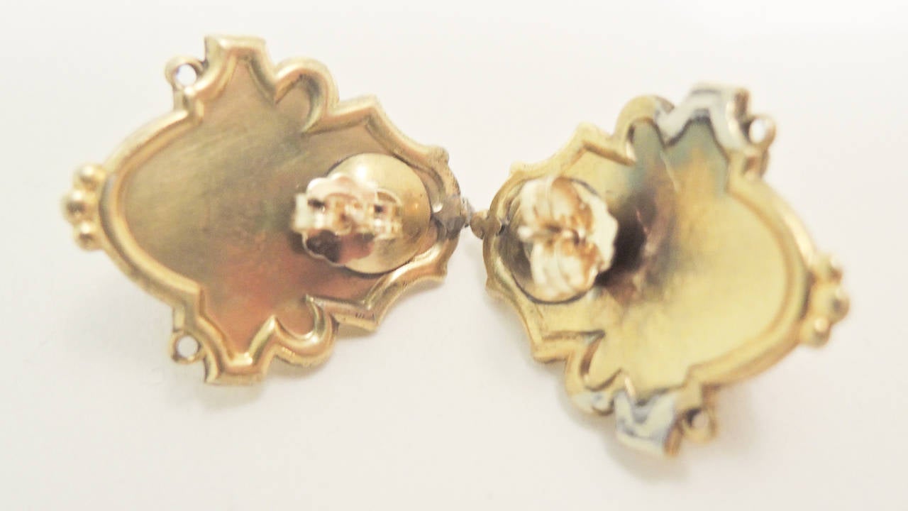 These Victorian earrings feature a heavily carved woman’s face in coral in an 18kt gold setting.  These pierced earrings measure 1” x 7/8” and are in excellent condition.