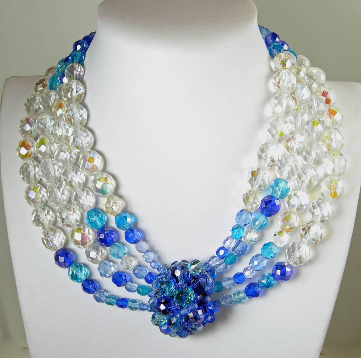 This vintage 1950s Coppola e Toppo Italy necklace features bezel cut, multi-color blue & clear glass bead multi-strand necklace in a gold-tone setting.  This necklace measures 17 1/2” long with a hook closure; the centerpiece grouping is 1 1/2” x 1