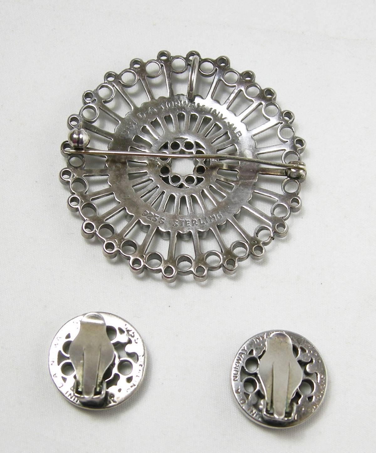 It is very unusual to find a set like this by David Anderson complete.  The pin can also be worn as a pendant.  It has an open work pinwheel design.  It is 2” in diameter.  The matching clip earrings are 1/2