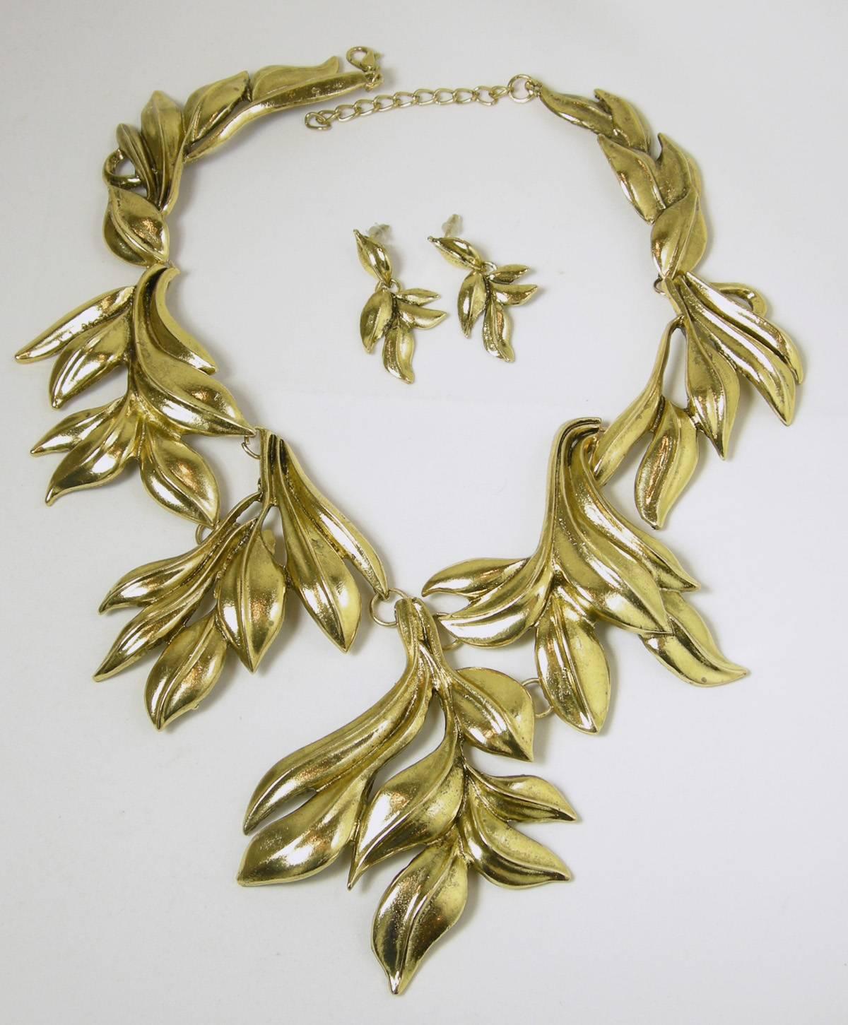 You will have fun wearing this unsigned Oscar De La Renta leaf motif necklace. It is bold and makes a statement. In a gold setting with a lobster clasp, this necklace measures 19” x 4”. The earrings measure 2” x 1/4