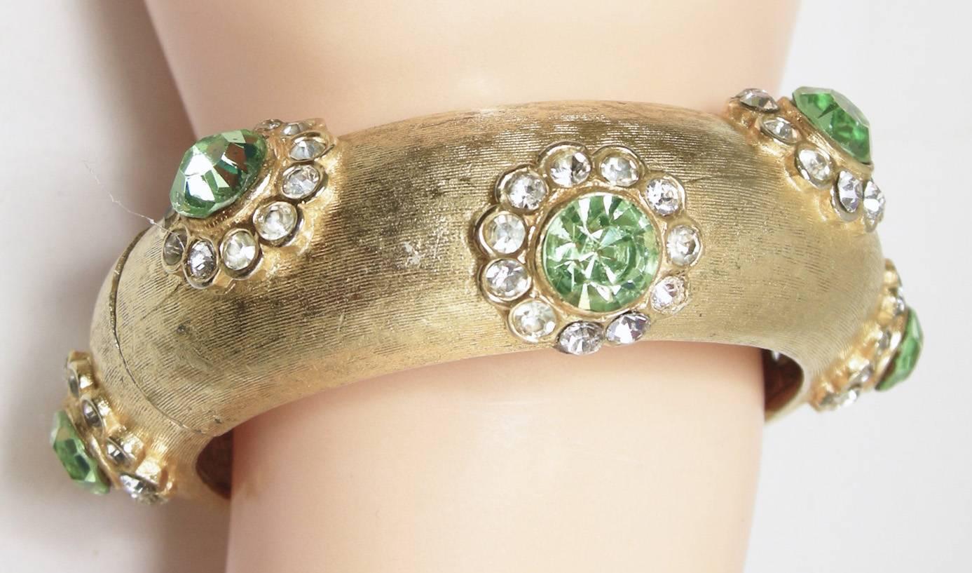 A most exquisite piece by CADORO, believed to date circa 1960s-1970s era.  This bracelet is ornately jeweled and very well crafted.  Hinged style, hinge mechanism works perfectly.  Heavy molded metal cuff with brushed gilded overlay, substantial at