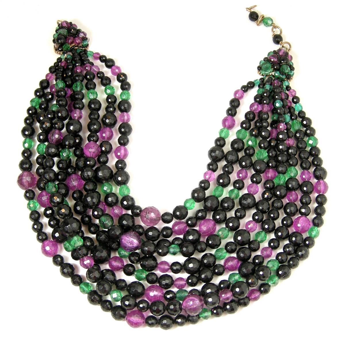 This wonderful vintage 90s 9 strand necklace by Coppola e Toppo has a multitude of colors of black, purple and green faceted Lucite beads.  Each end has Coppola’s famous beaded heart beads. The necklace is 17-1/2” and the front is 3-1/2” long and