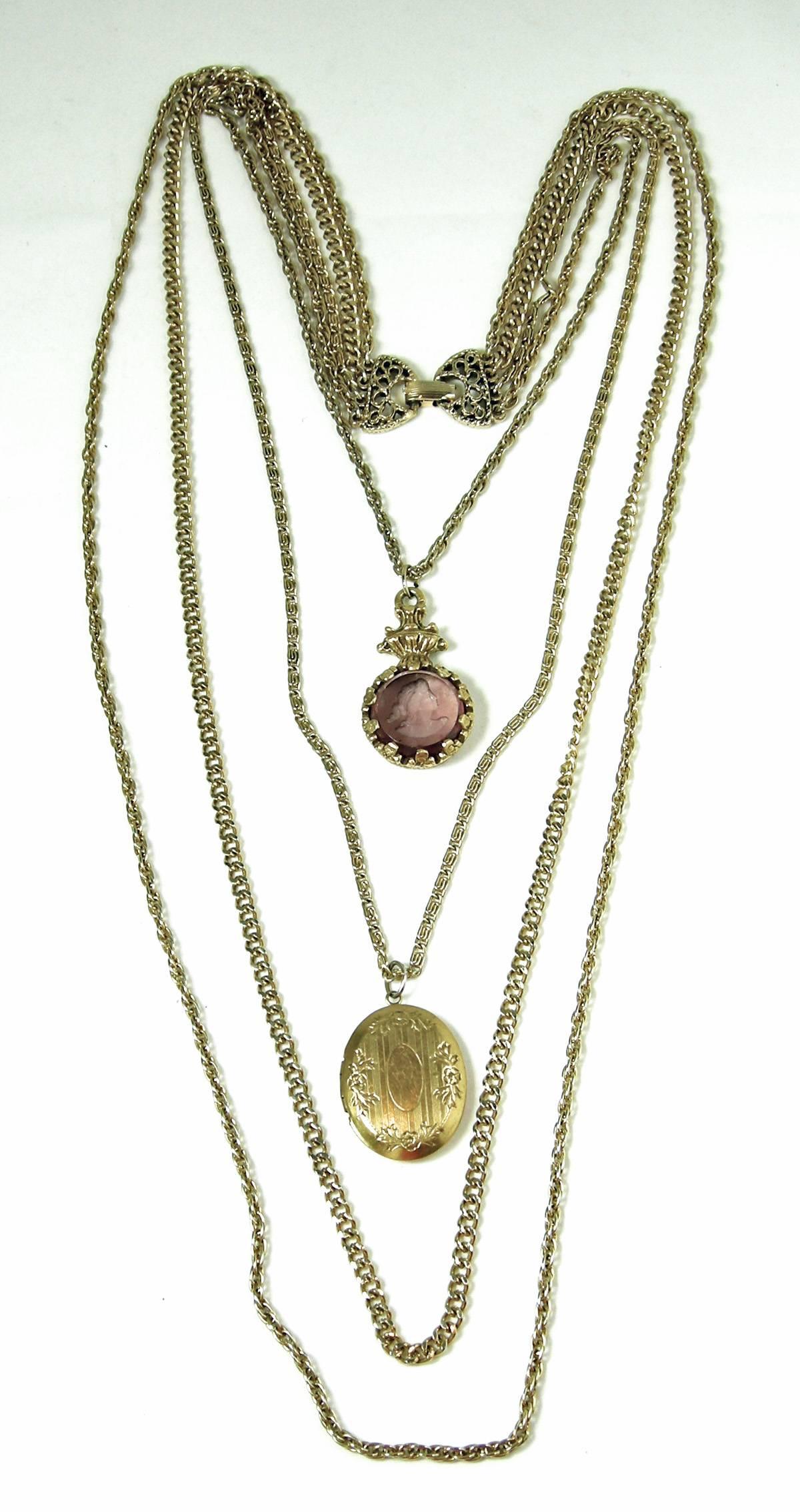  This vintage 1960s Goldette necklace is beautiful. It has 4 chains in a gold tone finish. The first chain is 19-1/2” x 1/4” with  a purple Intaglia cameo hanging in the middle. The second chain measures 21” x 1/4