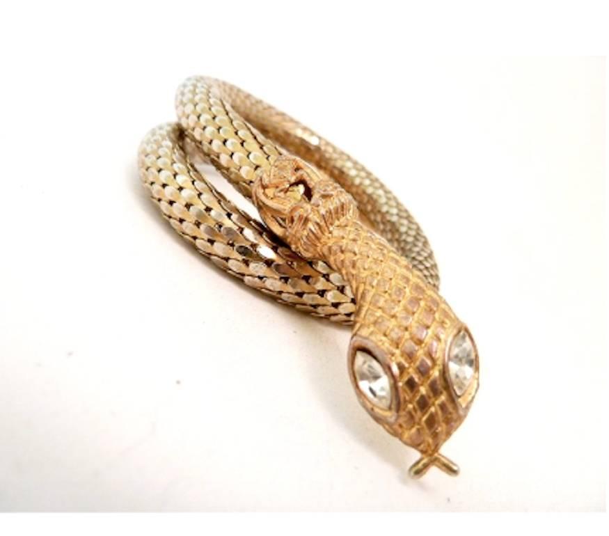 Another beautiful snake wrap bracelet by Whiting & Davis featuring a clear rhinestone eye accent in a meshed gold-tone setting. The snake head measures 5/8” wide and the adjustable bracelet is 15 ¼” around. This great Whiting & Davis wrap snake
