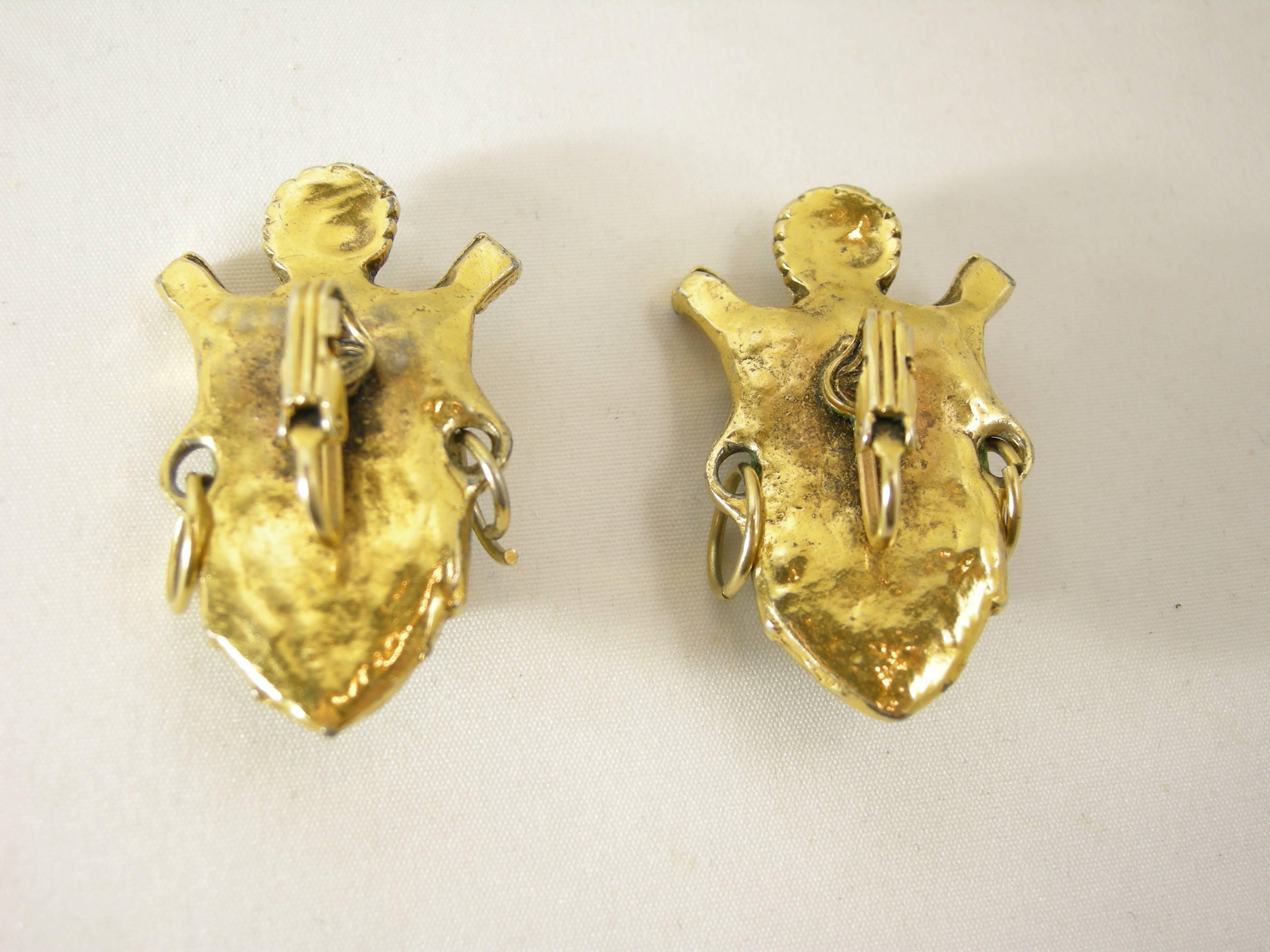 These are a pair of vintage Artisan vintage Selini Selro Asian princess earrings from the 50’s.  The princess is wearing her headdress over white resin with a gold tone setting.  These earrings measure 1-3/4” x 1”. They are unsigned but well-known
