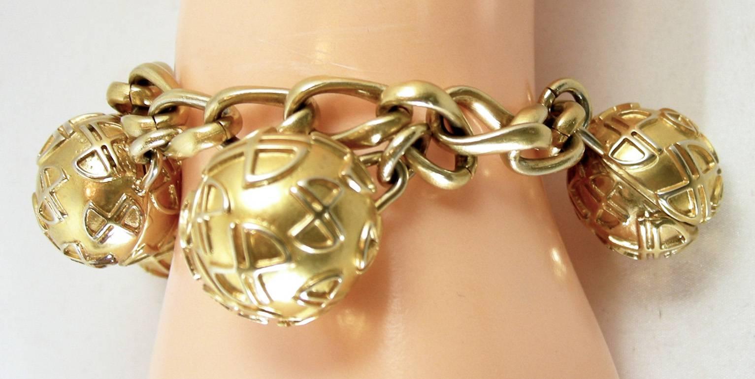 This is the famous 80s Jean Patou charm bracelet with 5 separate balls on a link chain in a gold-tone setting. Bracelet measures 8” and each ball is 7/8” with a toggle bolt closure signed “Jean Patou Paris”.  Bracelet is in excellent condition.