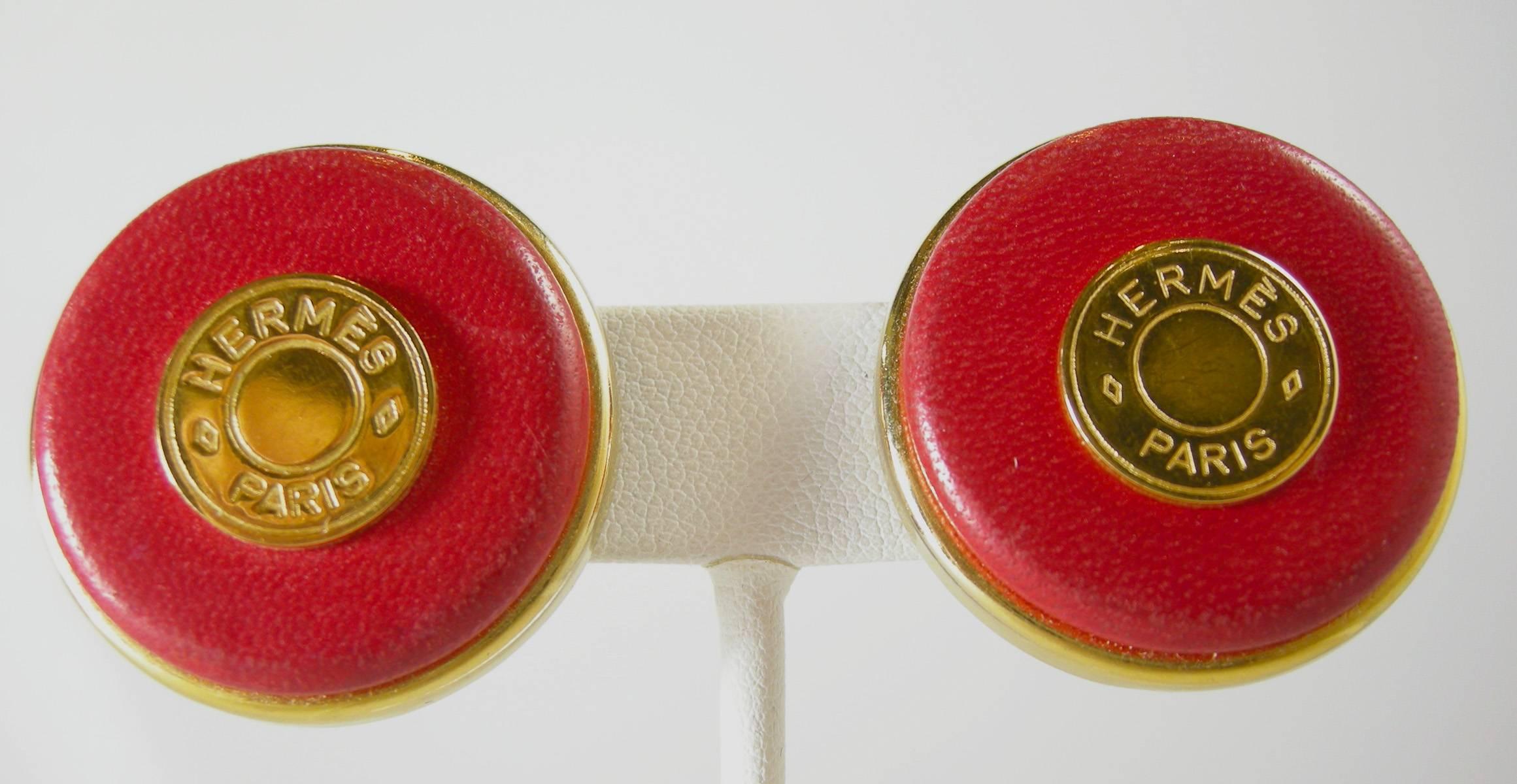 Gorgeous Hermes earrings feature a dark coral lucite disc design accented by a disc signed  “HERMES PARIS”.  In excellent condition, these clip earrings measure 1.5
