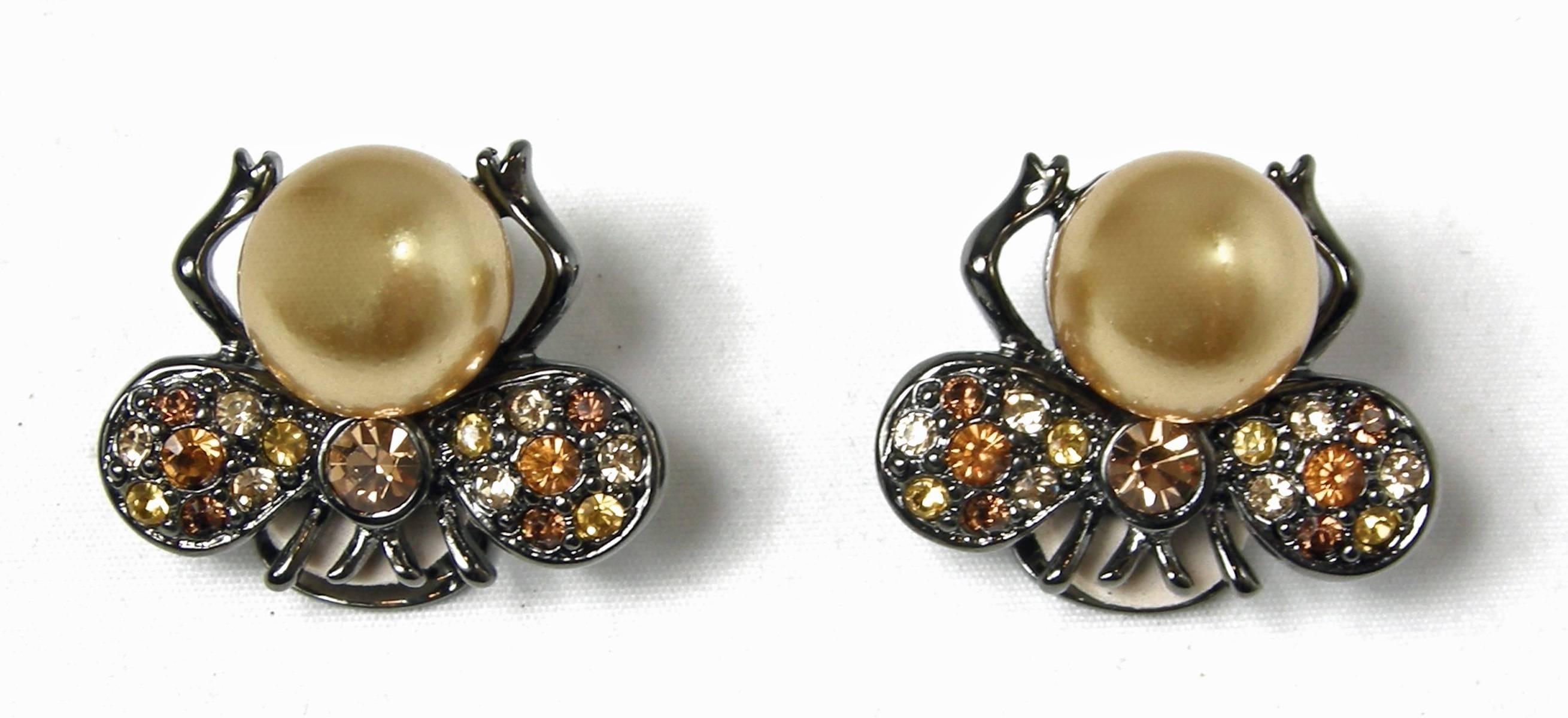 These Kenneth Jay Lane bee earrings are from his couture collection and have beautiful yellow and brown crystals. The body is a large sized cream colored faux pearl. They are set in a pewter colored glossy setting and measure 1