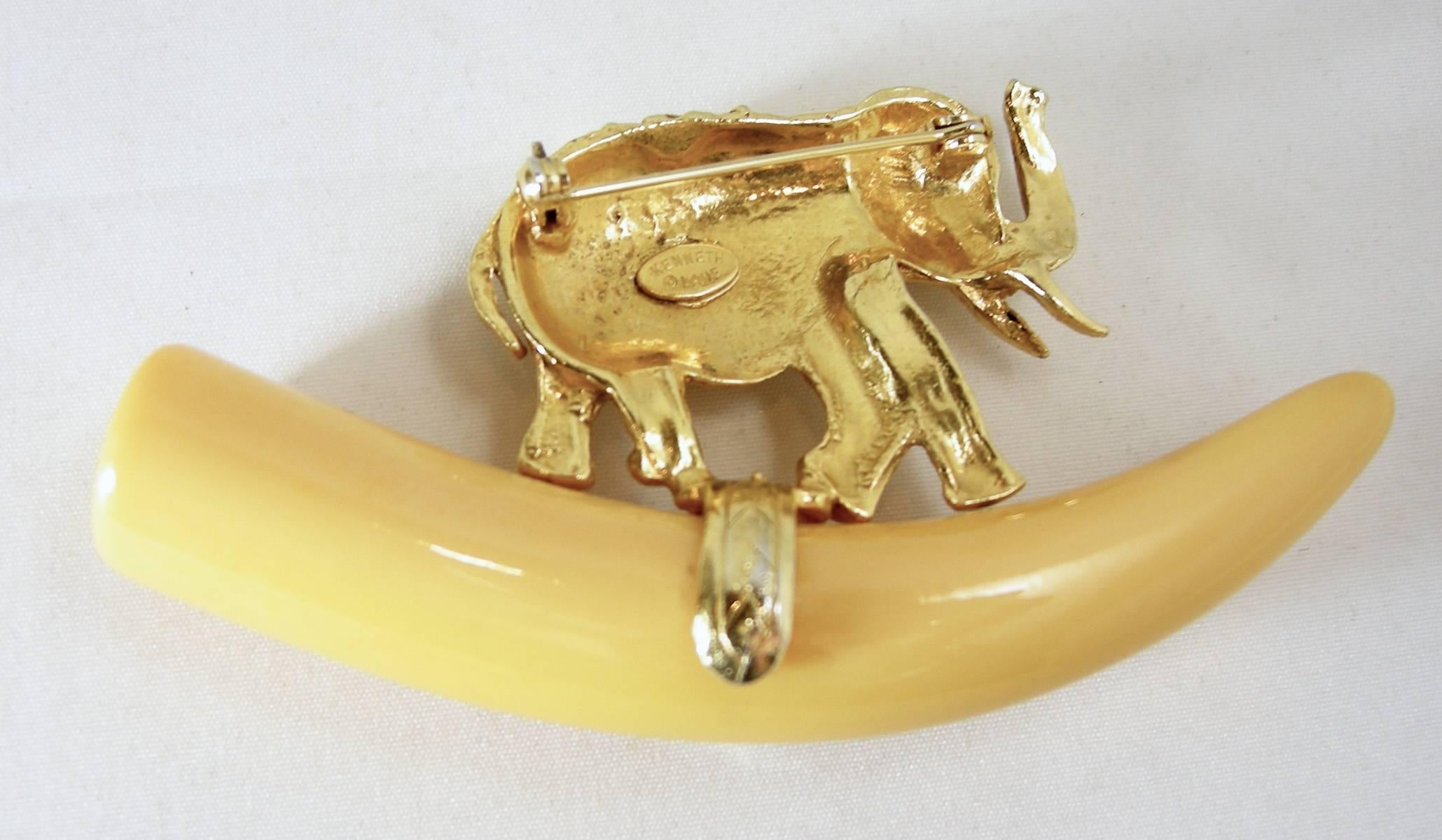 This Signed Kenneth Lane elephant on a resin tusk brooch is set in a gold tone setting and measures 3-1/2” x 2” It is in excellent condition.
