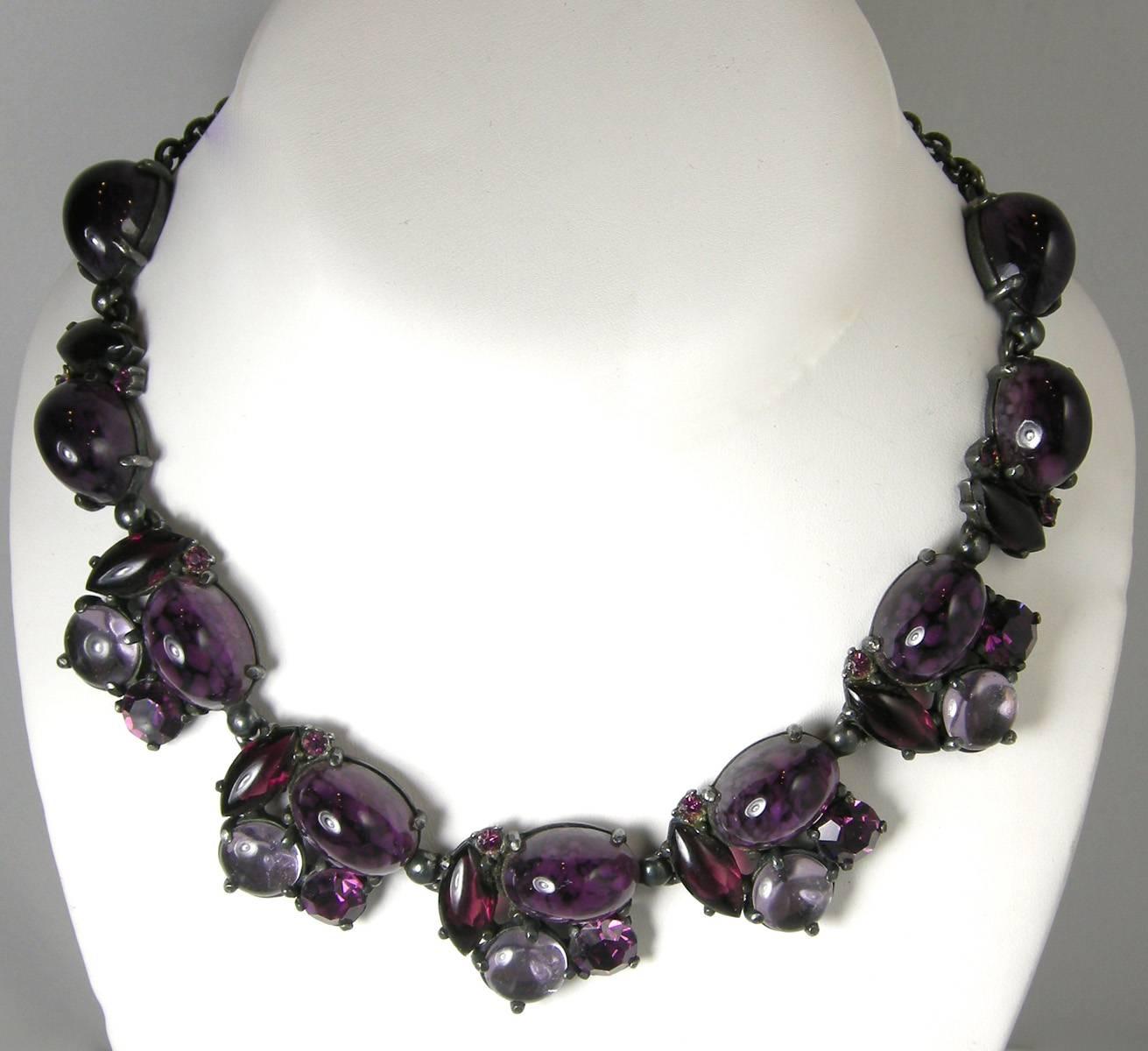 It’s almost impossible to find a full 50s Schiaparelli parure and this one is especially striking with rich amethyst colored glass accented by clear cabochon stones in a Japanned setting.  The necklace measures 16” x 1” with an adjustable hook