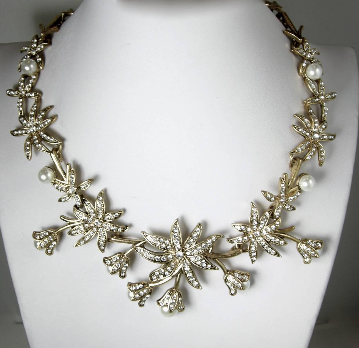 This beautiful Oscar de la Renta necklace has a floral design with Swarovski crystals and simulated pearls and sits beautifully on the neck.  The necklace is 16” but can be extended to 20” long.  It is 2-1/2” wide.  It is signed “Oscar de la Renta”.
