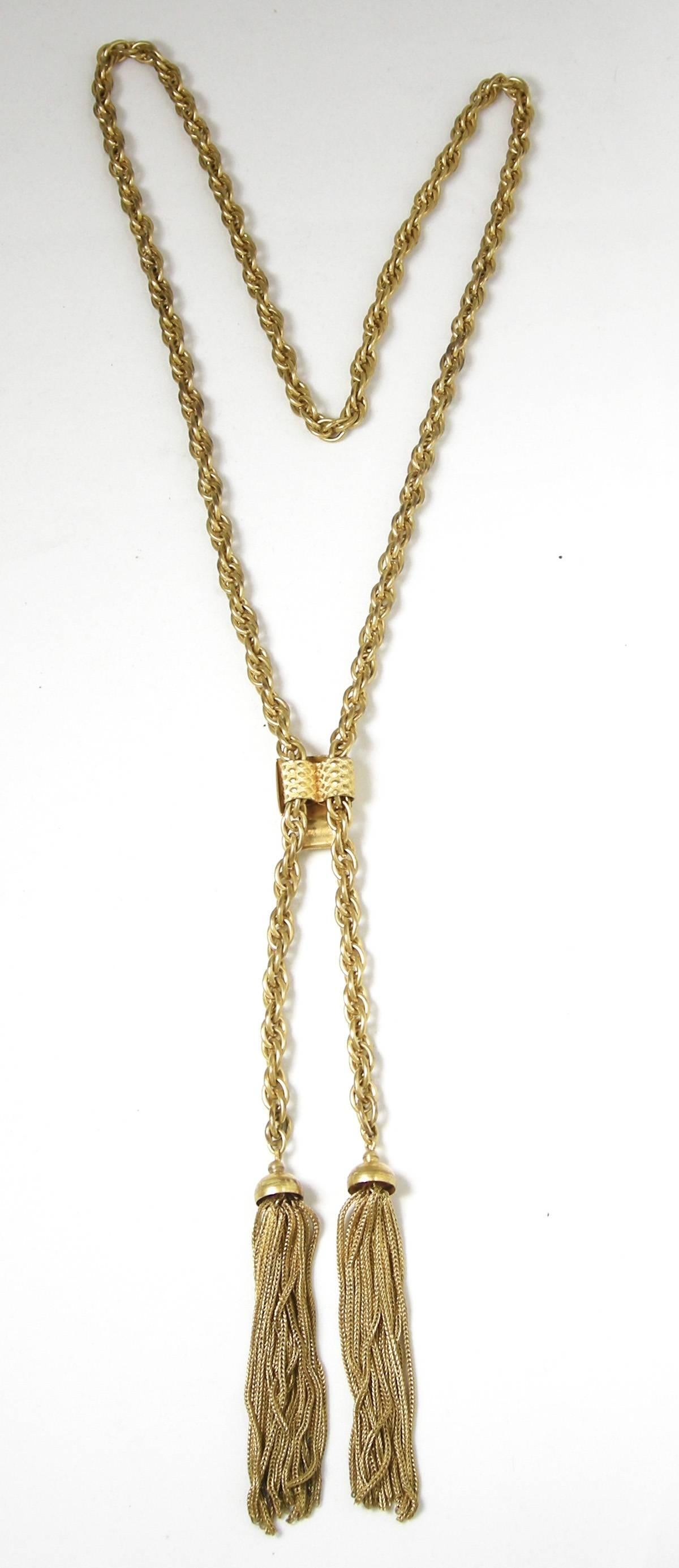 This is a 1960s tassel slide necklace with a rope chain design.  It measures 28” x 1/4” in a gold- tone metal finish.  It has a slide in clasp and is excellent condition.