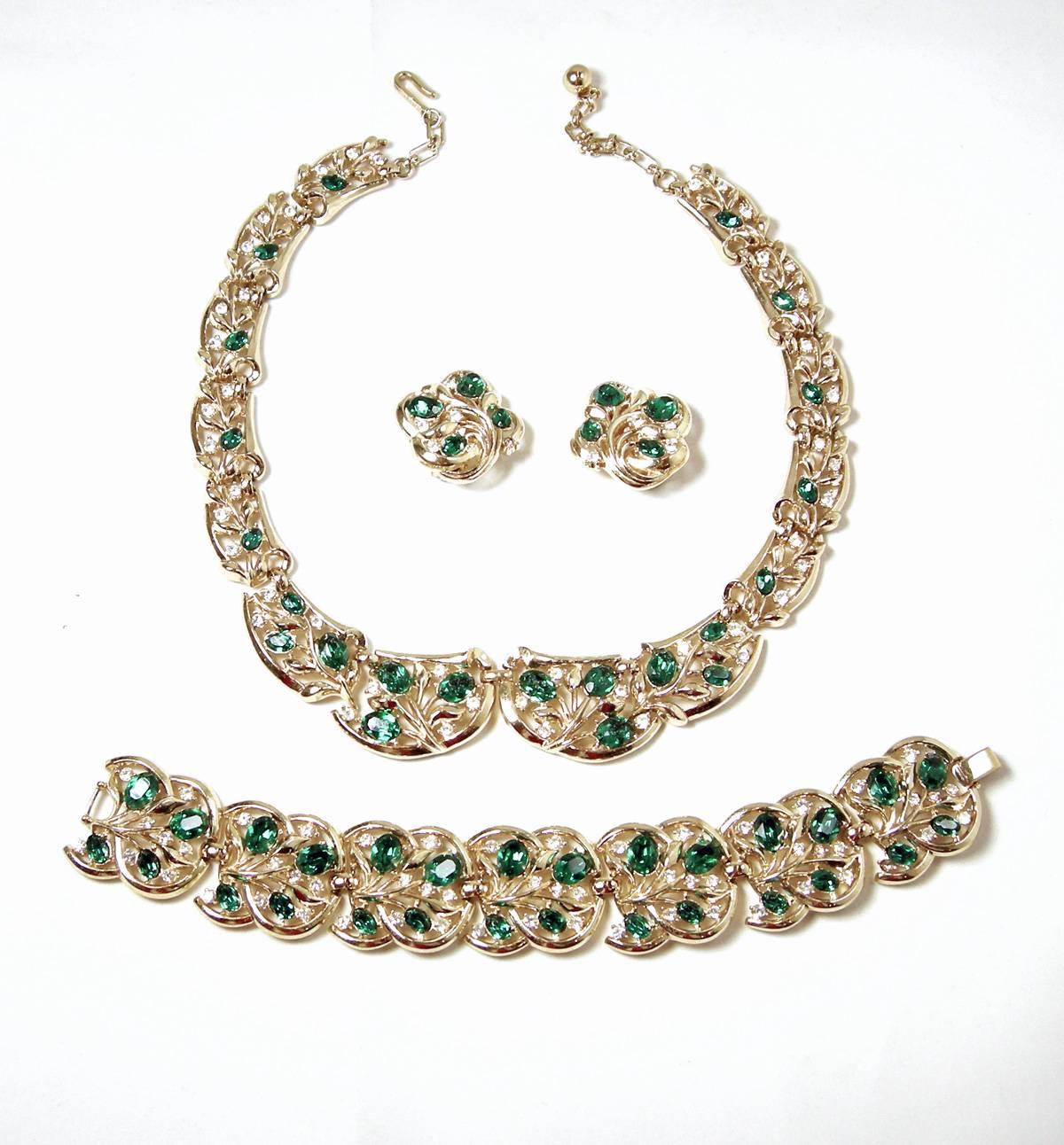 This is a beautiful vintage Trifari set with emerald green and clear rhinestones forming flowers in each segment.  There are five segments on each side, then they graduate to larger segments to the middle.  It is 16” with a hook clasp.  The middle