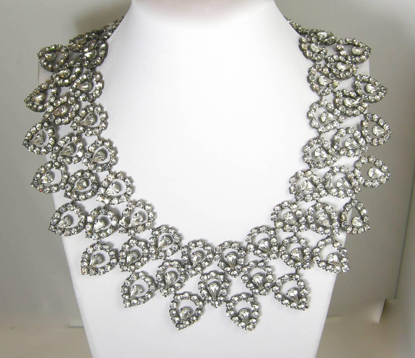 This dramatic 1980s collar Kenneth Jay Lane necklace is very dramatic.  Each intricate rhinestone row of teardrops is connected to each other and has a center pear shaped rhinestone inside.  It is 16” but can be extended to be worn 20”.  It is