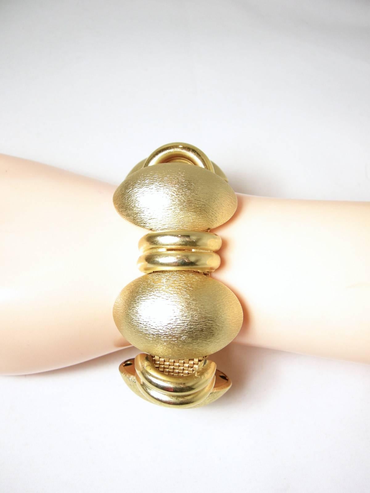 This is a big and bold stylish dome statement bracelet with an alternating design.  The bracelet has a mesh-like backing. It is set in a gold tone setting with a Florentine finish design. The bracelet measures 7-1/4” x 1-1/2” and is in excellent