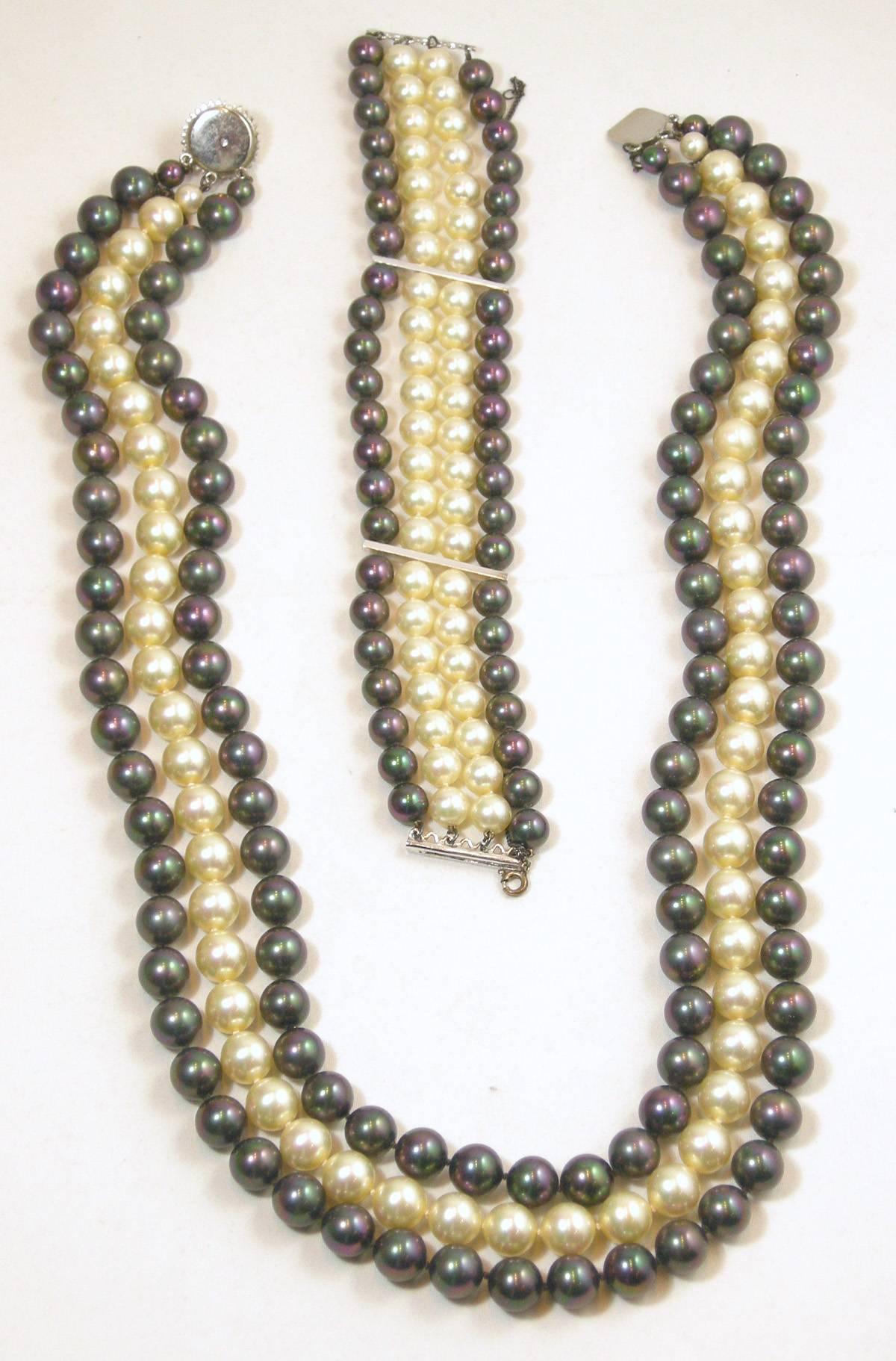 This is a wonderful faux pearl set from the 1950s.  The necklace has 3 strands of pearls…all hand tied.  The two outer strands have an iridescent grey color with a strand of white pearls in the middle.  The necklace is approx. 23” long and 1-1/2”