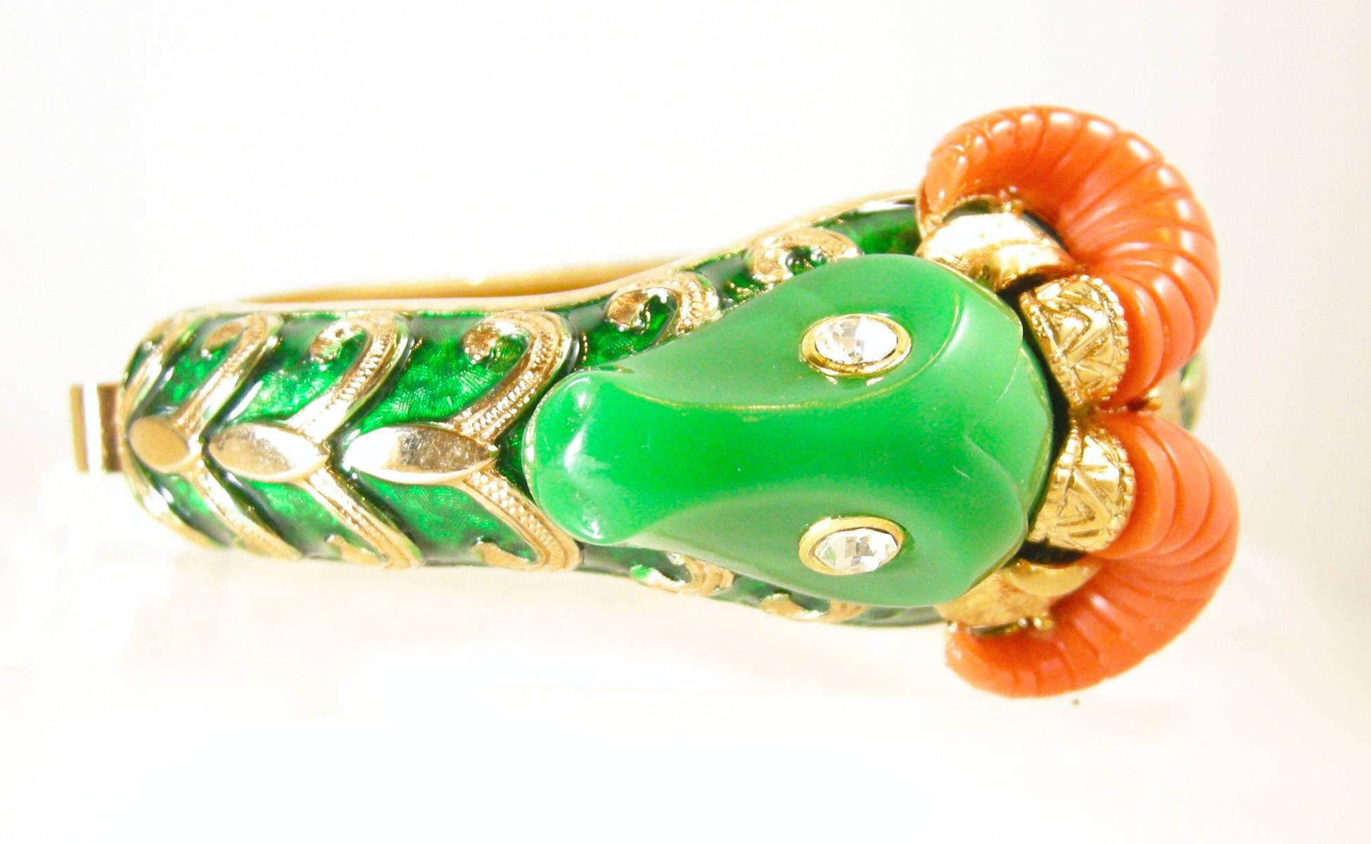 This is a rare vintage Kenneth Jay Lane with the old K.J.L signature.  This ram bracelet is made of a dark green enamel with a gold tone swirl design.  The head is made with a dark green resin and has clear crystals for eyes. The horns are coral