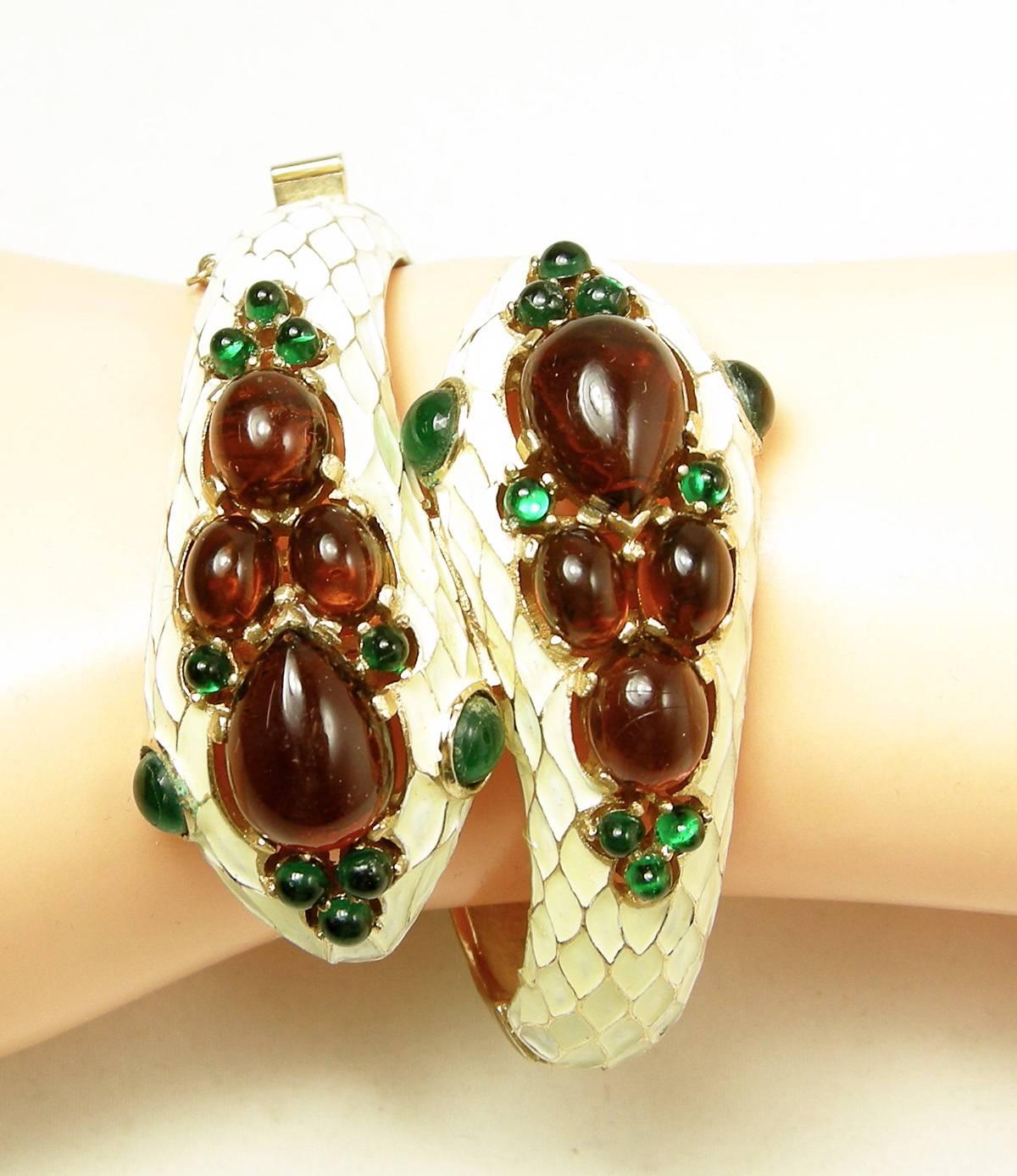 This is a great vintage Trifari snake bracelet.  It has topaz and green poured glass glass on white enamel scales accented with a gold tone metal finish.  It has a slide-in clasp with a safety chain and will fit a 6-1/2-7” wrist.  The snake heads