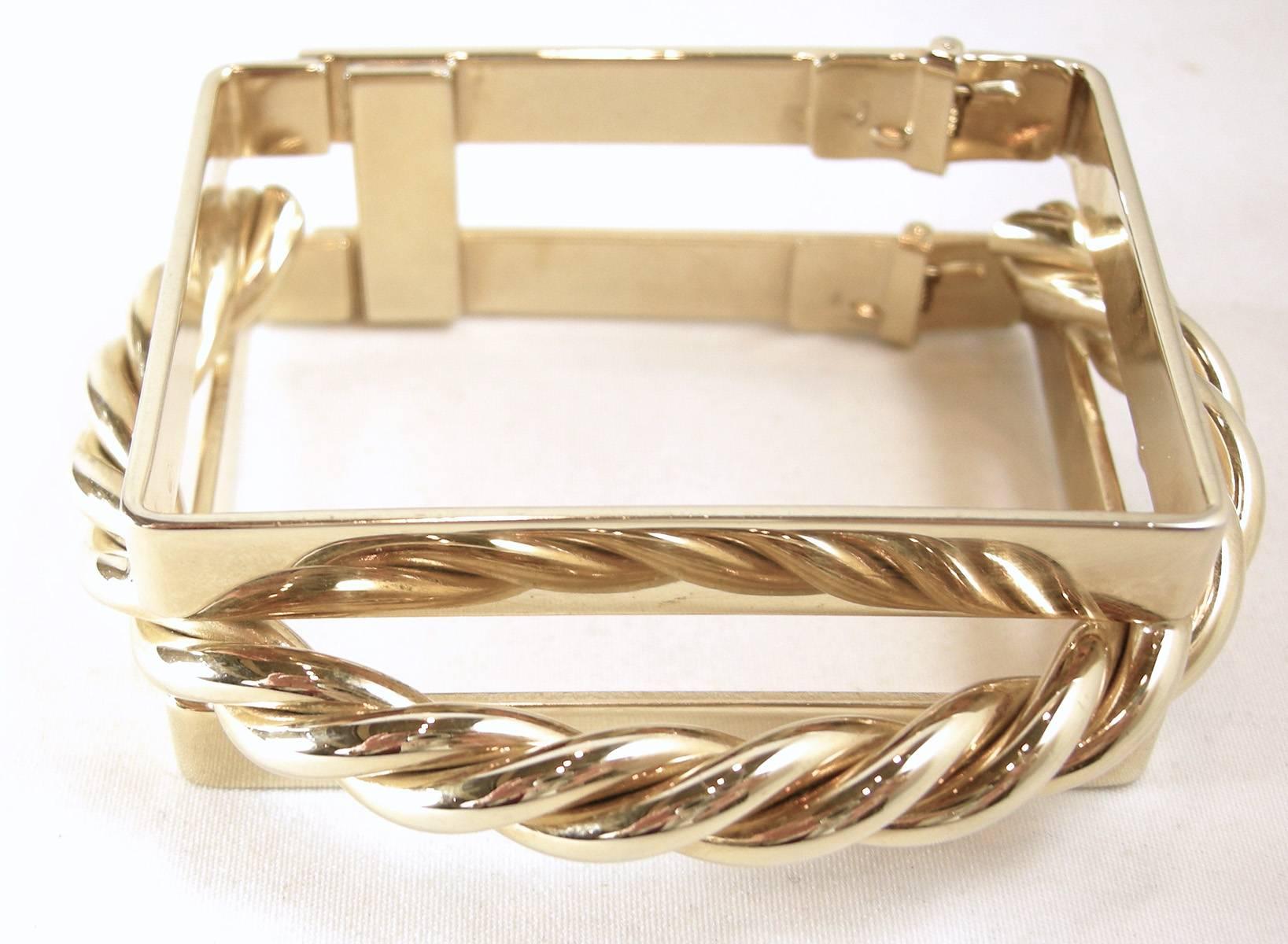 This bracelet has to be a designer piece.  It is so unique and looks like real gold.  It has a square shape with a gold-tone rope between 3/4 of the bracelet.  It has a hinge opening so it’s put onto the wrist like a clamper bracelet. The photograph