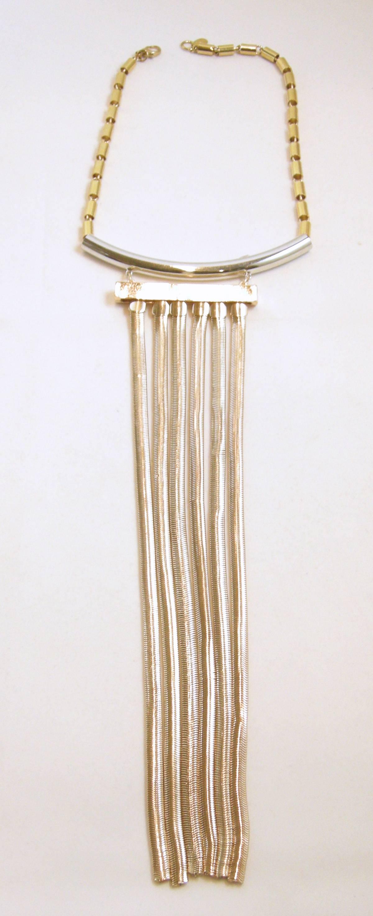 This is a stylish and gorgeous choker that has the top portion of the necklace made with a gold tone square linked chain. The center has a silver tone funnel with six golden tassels hanging from it. The necklace measures 15” x 1/4”. The tassels