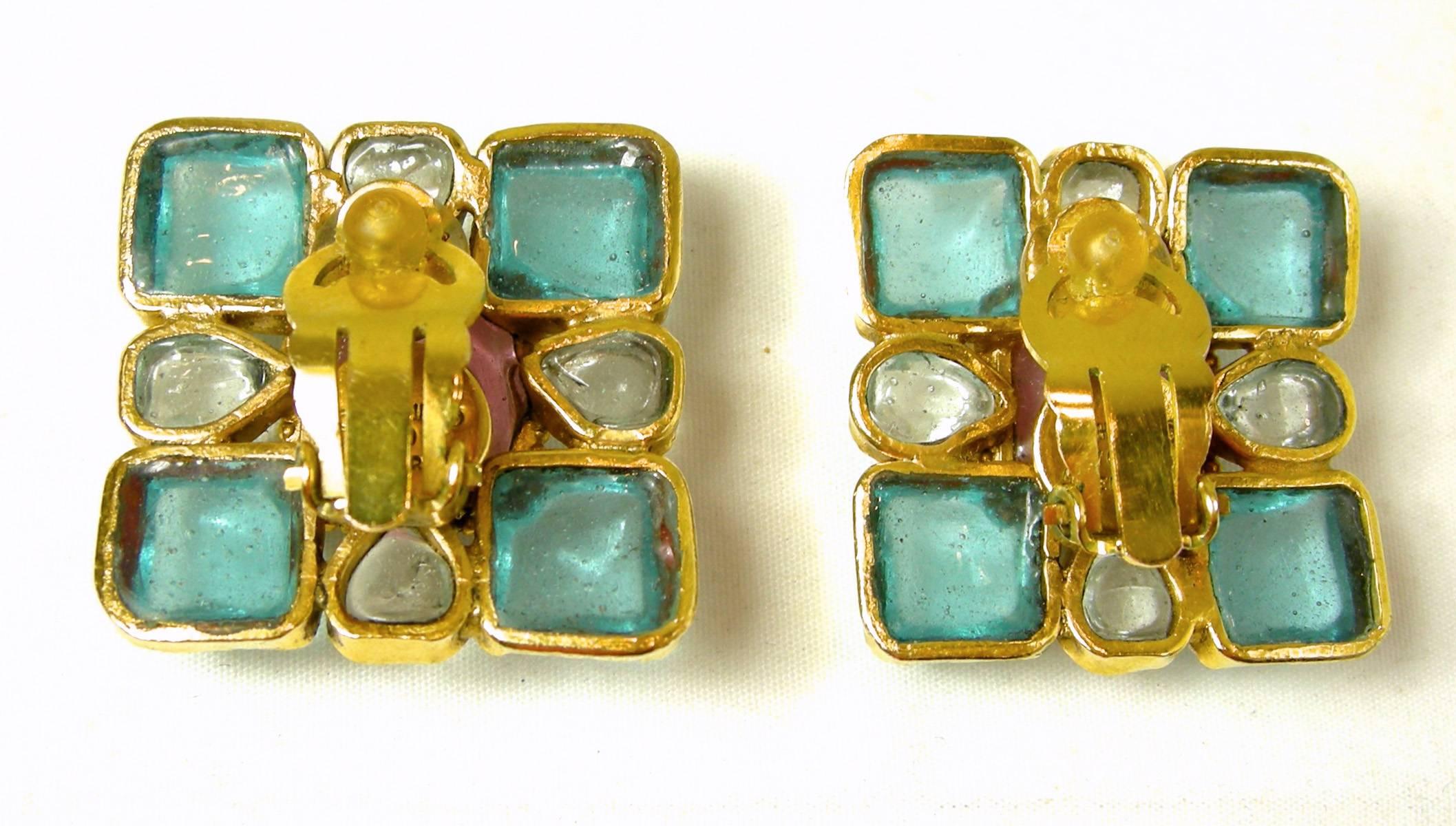 These are pair of charming pink, blue and clear Chanel Gripoix glass earrings that are oval and square in shape. They are set in a gold tone setting and measures 1-1/8” x 1-1/8”.  It is signed “Chanel” 97 P made in France”.
