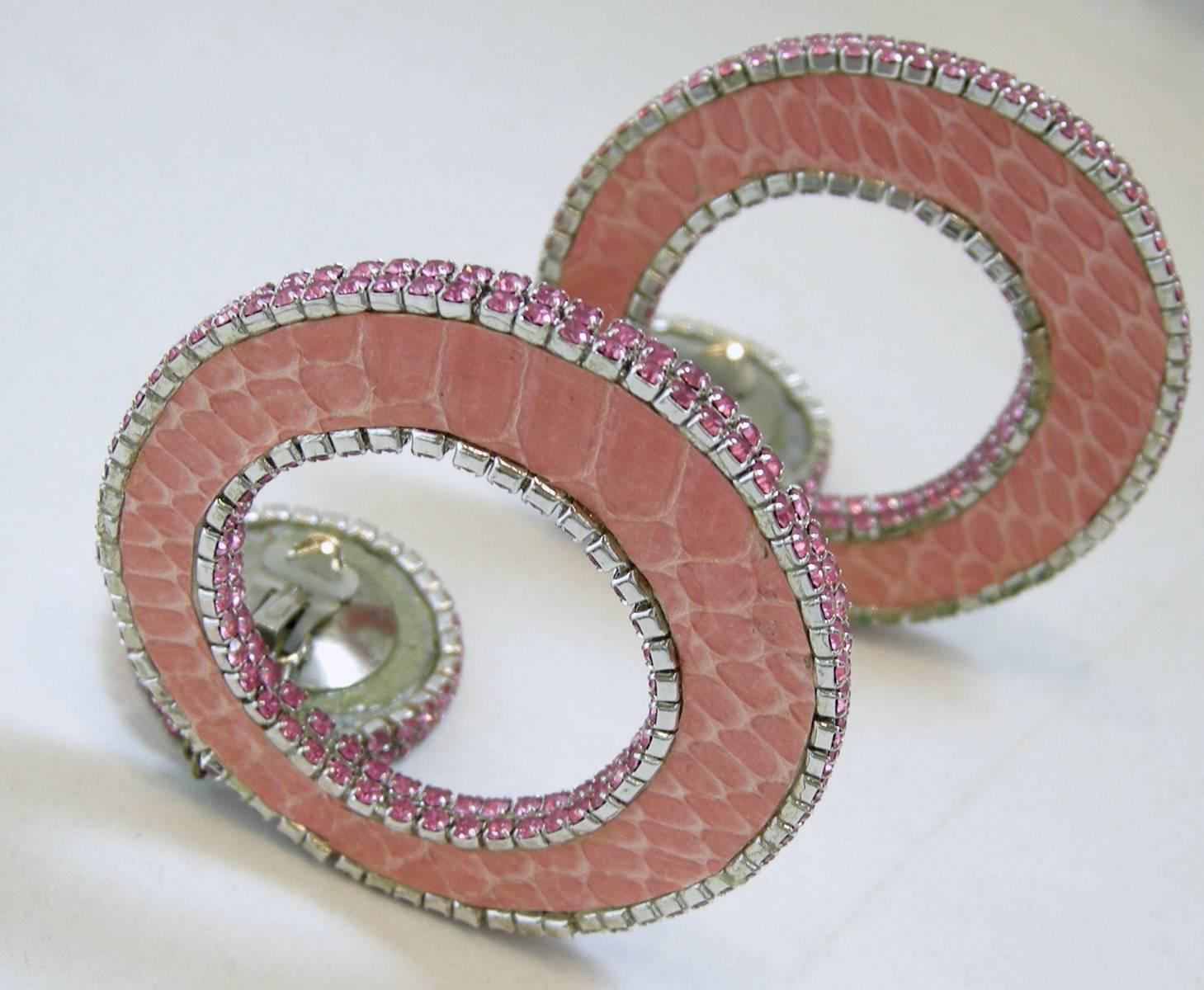 These Vintage happy earrings were made in the 1970s. They were made with a pink faux snake skin design with rhinestones that make them dramatic and elegant at the same time. They are in a silver tone setting and measure 4” x 2 ½”.  They are in