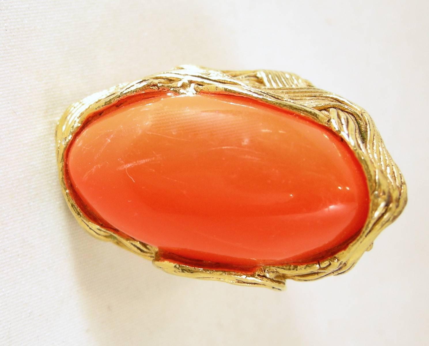 This is a bold oval shaped vintage faux coral stone ring from the 1980s.  It’s in a gold tone metal setting. The top measures 1-1/2” long and 1” wide. It is a size 8, unsigned, and is in excellent condition.