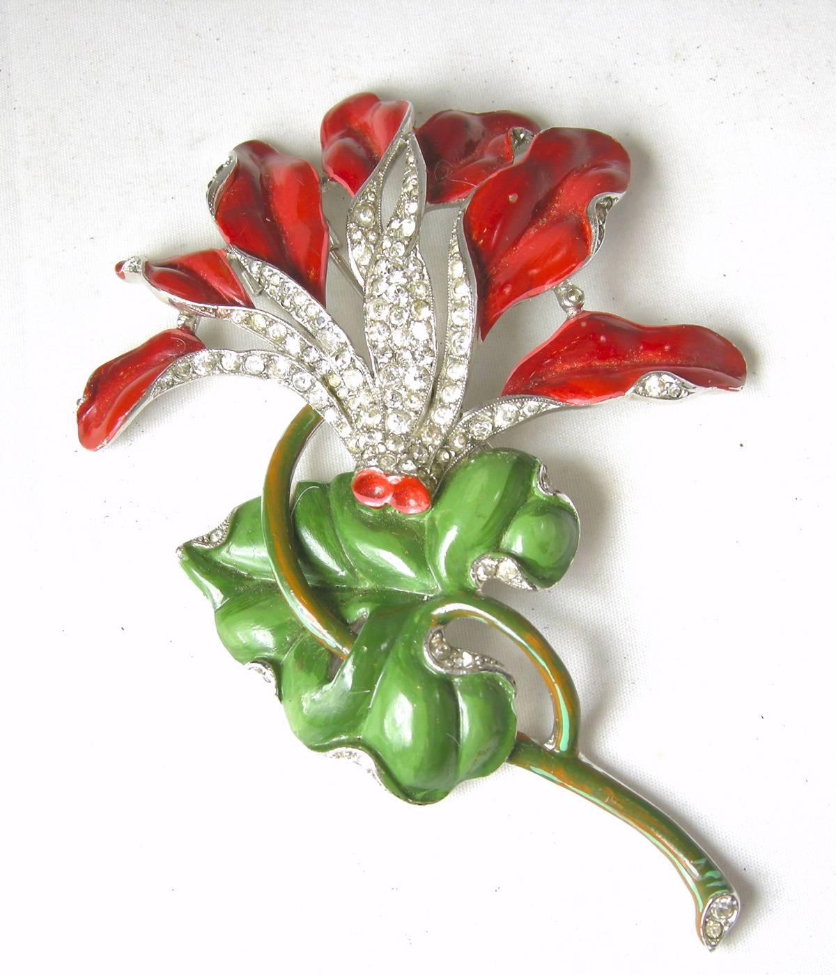 This is one of the rare and famous Trifari flower fur clips that are highly collectable. It features a beautiful green and red enamel carnation with clear diamante rhinestones.  It is set on a rhodium silver finish. It is signed “Trifari” with the