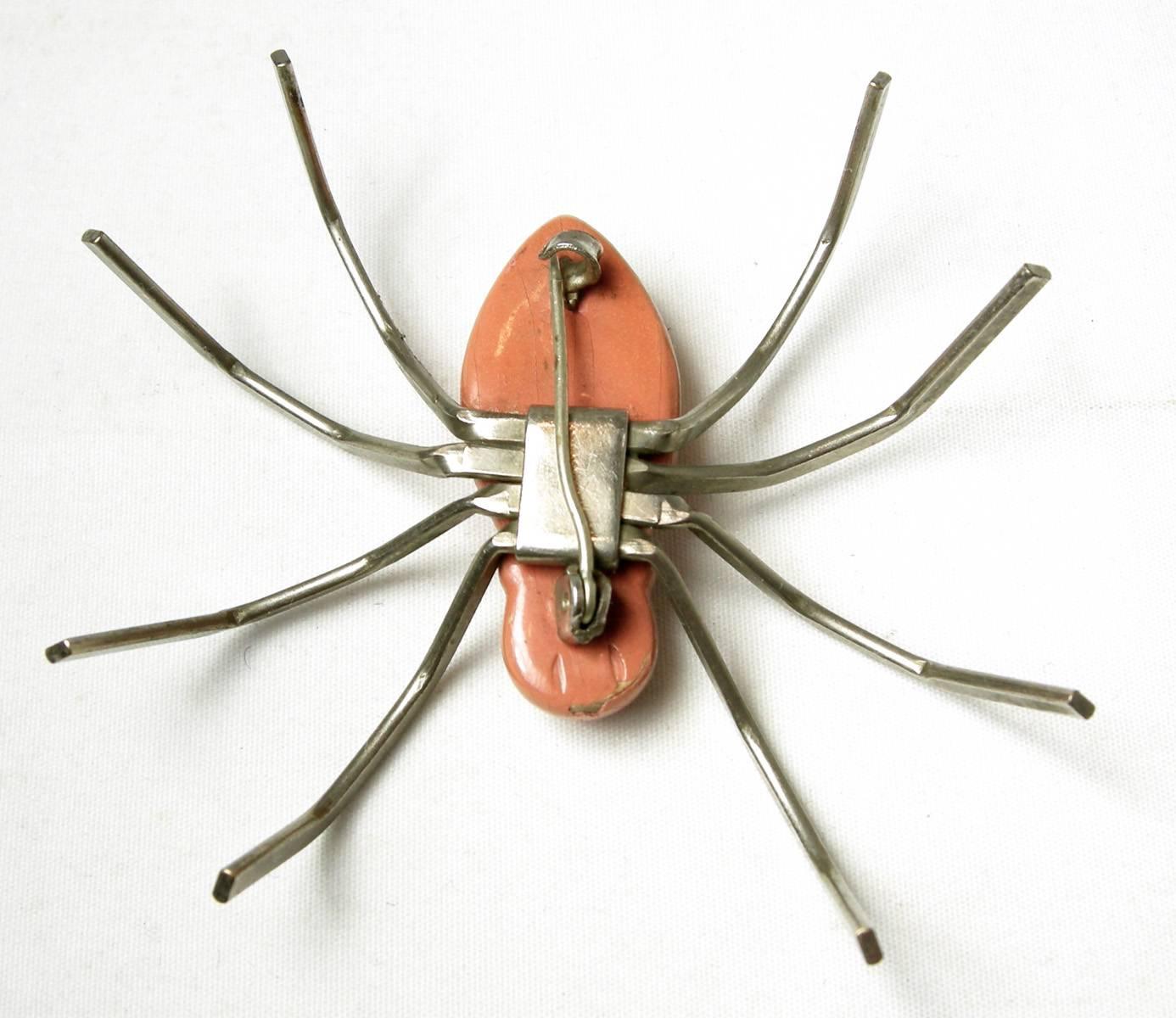 This spider pin is a charming whimsy piece. The body is made of a coral & black color enamel. The legs are in a silver tone setting. This spider pin measures 2-1/8” x 2-1/2”. It is in excellent condition.