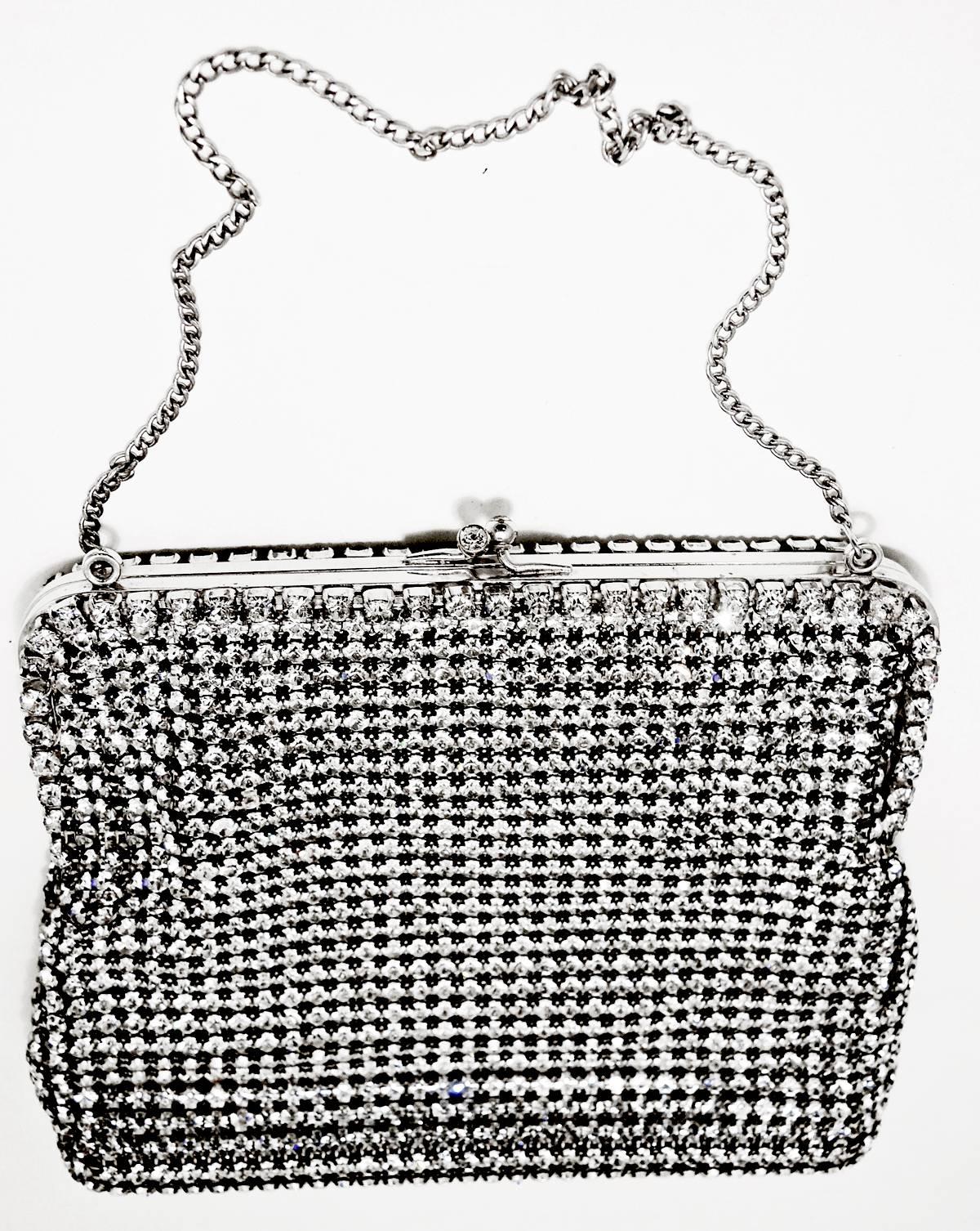This Calem clutch purse is embellished with vibrant clear rhinestones throughout the bag. It has a rhinestone twist back clasp. It has the original mirror, change purse and two compartments to put your belongings in. The inside is made with a