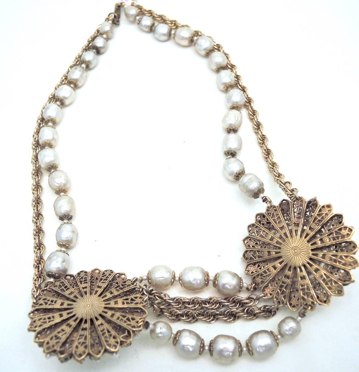 This Miriam Haskell necklace is a beauty!  It features two faux pearl medallions that are decorated with smaller pearls. The center has a 3-dimensional pearl in the center and is covered with rose montee.  The necklace itself has small pearl spacers