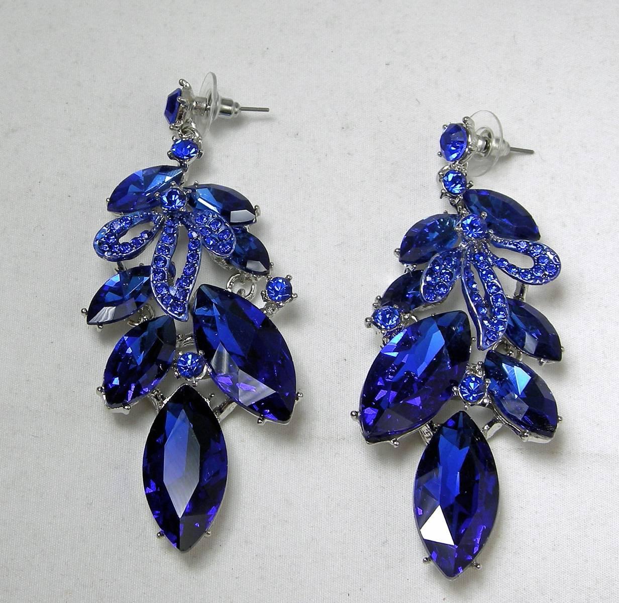 These elegant electric blue pierced earrings are real show-stoppers.  They are in a silver tone setting with sparkling prong set blue rhinestones streaming downward. They measure 3” x 1-¼”.  They are in excellent condition.