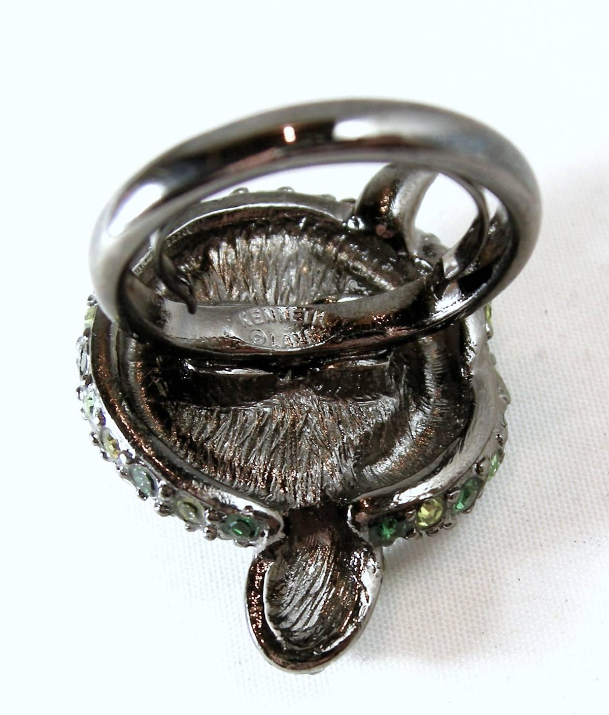 This fun turtle ring features a ribbed onyx simulated stone in the center acting as the turtle’s shell.  There are different shades of green rhinestones while the eyes are red rhinestones sitting in a clear rhinestone head. It is in a pewter tone