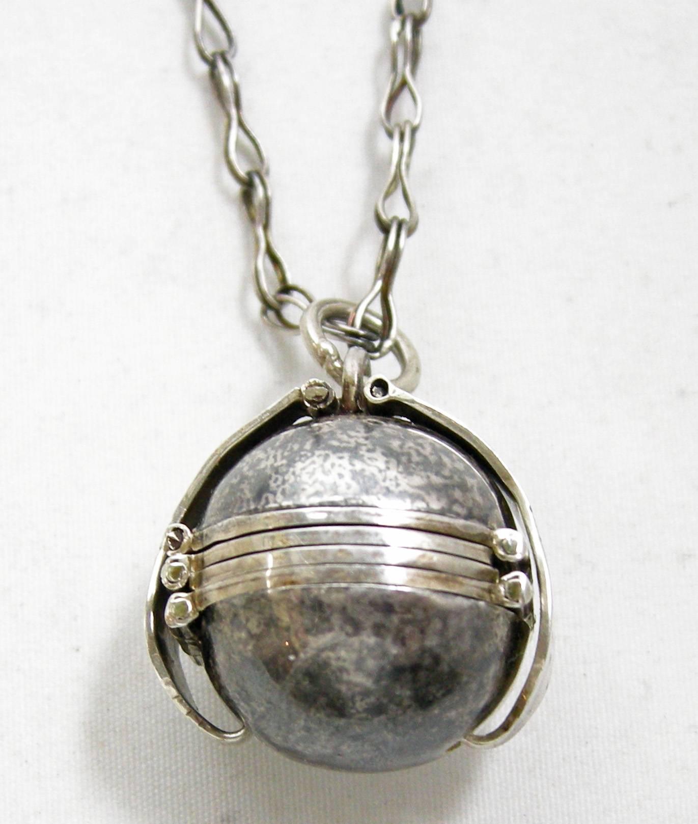 Here we have a cherished Art Deco 1920s keepsake ball locket-pendant-necklace. This lovely piece can hold up to 4 photos. It is made of sterling silver and measures 3/4” x 3/4”. The necklace measures 24” x ¼” and has the old original hook connector.