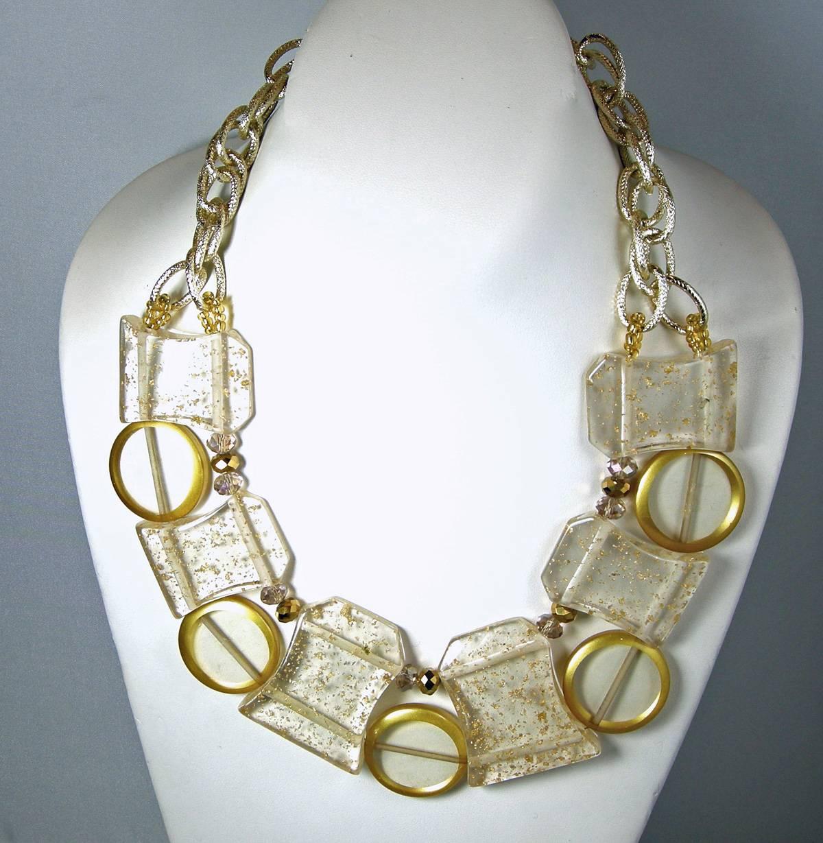 This beautiful 1950s Lucite necklace has huge Lucite spheres with golden flakes that graduate in size to the center. It has round Lucite circles in between each sphere.  It is 21” long with an open link chain that leads up to a lobster clasp.  The