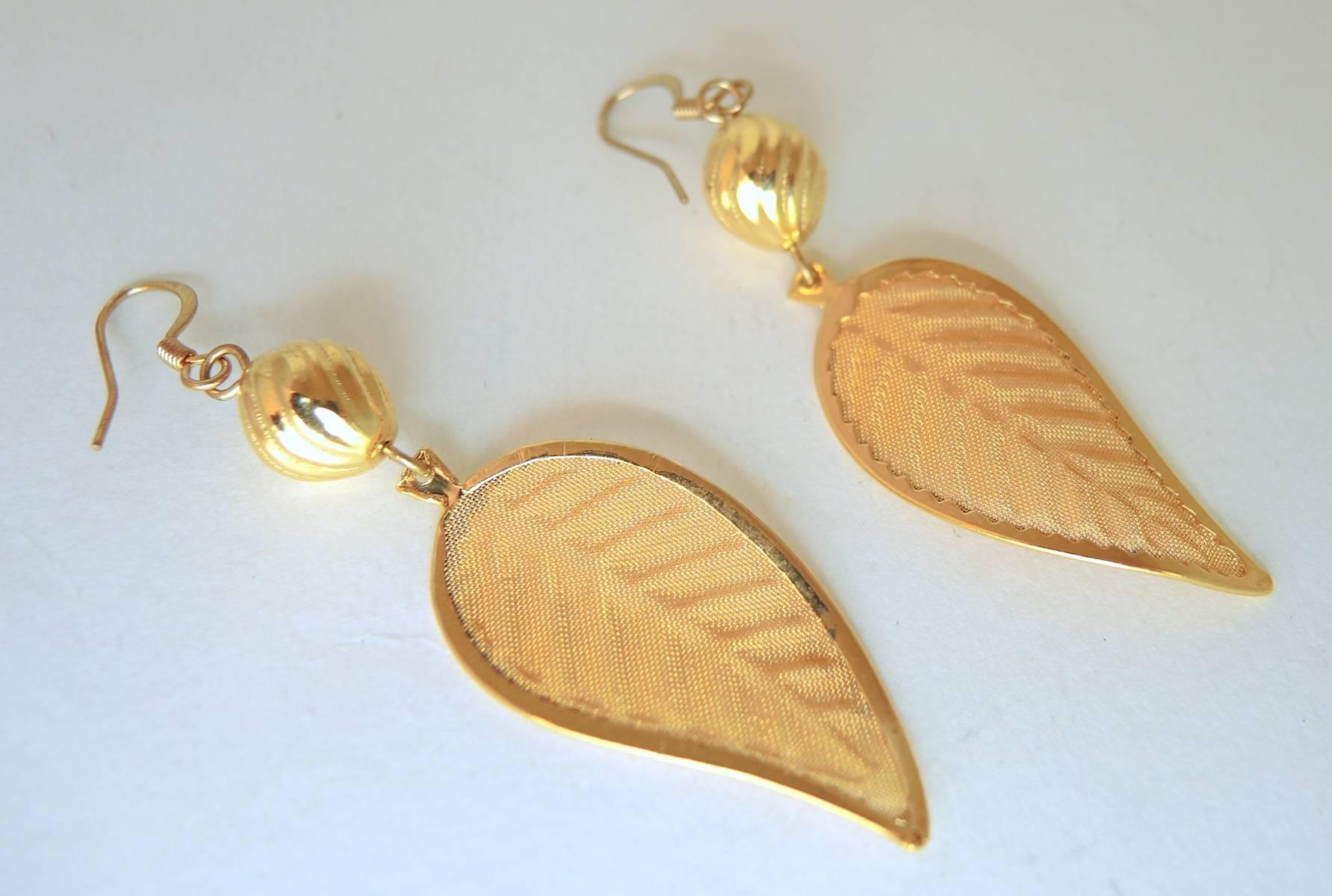 These very feminine earrings feature a leaf design in a gold-tone mesh setting.  They are pierced earrings and measure 2-1/2” x 3/4”.  These earrings are in excellent condition.