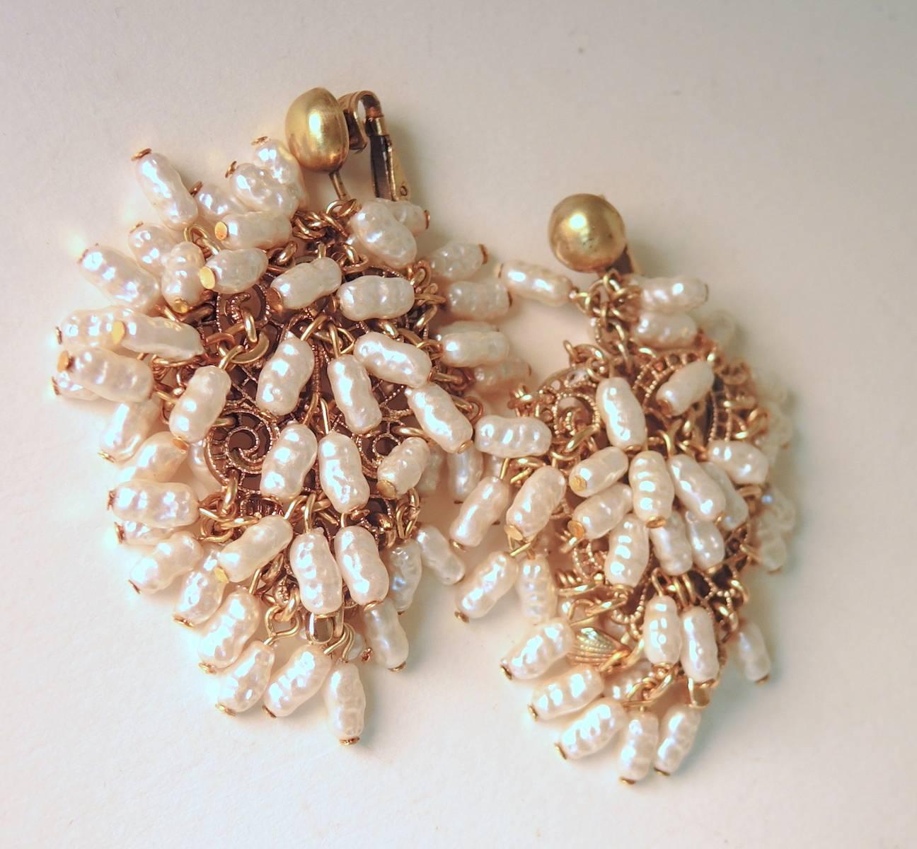 These beautiful statement earrings by Vogue are made with a massive amount of tiny faux pearls in a gold-tone setting.  These clip earrings measure 2-1/2” x 2” and are signed “Vogue”.  They are in excellent condition.